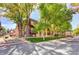 Inviting exterior of brick apartments nestled among mature trees and a well-maintained lawn at 7755 E Quincy Ave # 104A1, Denver, CO 80237