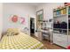 Bedroom features a colorful bedspread, a window with natural light, and built-in shelving at 1776 S Logan St, Denver, CO 80210