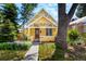Charming yellow home with a well-manicured front yard and walkway leading to the entrance at 1776 S Logan St, Denver, CO 80210
