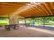 Community pavilion interior showcasing picnic tables, an art mosaic, an open-beam ceiling, and ceiling fans at 4129 Amber St, Boulder, CO 80304