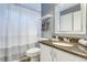 Well-lit bathroom featuring a shower with a curtain, granite countertop, and a large mirror at 6365 Xavier Ct, Arvada, CO 80003