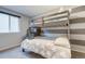 Bunk room featuring stylish bunk beds, a window for natural light, and gray striped wall decor at 6365 Xavier Ct, Arvada, CO 80003