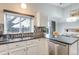 Eat-in kitchen features dark countertops, stainless steel appliances, and sliding doors to the backyard at 6365 Xavier Ct, Arvada, CO 80003