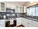 Charming kitchen with stainless steel appliances, granite countertops, and white cabinetry at 6365 Xavier Ct, Arvada, CO 80003