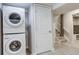 Convenient laundry area featuring a stacked washer and dryer with easy access to the stairs at 6365 Xavier Ct, Arvada, CO 80003