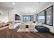 Modern living room with a fireplace, a large sectional sofa, and large picture windows at 46692 Silver Fir St, Parker, CO 80138