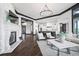 Open-concept living room with modern furniture, stone fireplace, and seamless flow to the kitchen at 46692 Silver Fir St, Parker, CO 80138