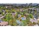 Lush greenery surrounds the home in this aerial view, showcasing the pool, tennis court, and serene neighborhood at 6488 S Heritage E Pl, Centennial, CO 80111