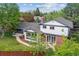 A backyard with mature trees, a lawn, and a stone patio with a covered portion of the house at 6488 S Heritage E Pl, Centennial, CO 80111