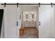 Beautiful bathroom with barn door entry, double vanity, and wood-look tile flooring at 6488 S Heritage E Pl, Centennial, CO 80111