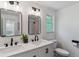 Well lit bathroom with double sinks, framed mirrors, and updated fixtures at 6488 S Heritage E Pl, Centennial, CO 80111