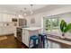 Bright and modern kitchen with white cabinets, stainless steel appliances and island seating at 6488 S Heritage E Pl, Centennial, CO 80111