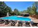 A refreshing pool area featuring lounge chairs, umbrellas, and a nearby cabana on a sunny day at 6488 S Heritage E Pl, Centennial, CO 80111