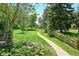 Scenic walking path meanders through lush green space with mature trees and rustic fencing at 6488 S Heritage E Pl, Centennial, CO 80111