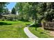 Serene walking path through lush greenery with mature trees in a well-manicured outdoor setting at 6488 S Heritage E Pl, Centennial, CO 80111