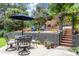 Outdoor dining area featuring a table and chairs under an umbrella, with a firepit and lush greenery at 8291 S Krameria Way, Centennial, CO 80112