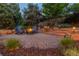 Backyard stone patio area with fire pit and chairs surrounded by mature landscaping at 8291 S Krameria Way, Centennial, CO 80112