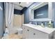 Bright bathroom featuring blue textured wallpaper, a white vanity, and a shower-tub combo at 8291 S Krameria Way, Centennial, CO 80112