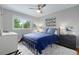 A blue bedroom has a metal-framed bed, white shag rug, exterior window, and side tables with lamps at 8291 S Krameria Way, Centennial, CO 80112
