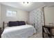 Simple bedroom with a metal bed frame, curtains, a small window, and record collection at 8291 S Krameria Way, Centennial, CO 80112