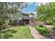 Charming two-story home with a well-manicured lawn, mature trees, and a stone pathway leading to the entrance at 8291 S Krameria Way, Centennial, CO 80112
