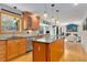 Open kitchen with wood cabinets, granite counters, stainless appliances and a view to the living room at 8291 S Krameria Way, Centennial, CO 80112