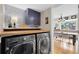 A well-organized laundry room features a front-load washer and dryer with folding countertop and decorative tile backsplash at 8291 S Krameria Way, Centennial, CO 80112
