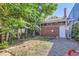 Backyard featuring a brick exterior, a small garden, and a gravel patio at 2303-2305 W 32Nd Ave, Denver, CO 80211