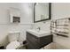 Bathroom featuring sleek black vanity, framed mirror, and a modern sink at 2303-2305 W 32Nd Ave, Denver, CO 80211