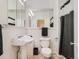 Classic white bathroom with pedestal sink, vintage mirrored cabinet, and black and white shower curtain at 2303-2305 W 32Nd Ave, Denver, CO 80211