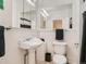 White bathroom with pedestal sink, toilet, mirrored cabinet, and black and white shower curtain at 2303-2305 W 32Nd Ave, Denver, CO 80211