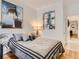 Cozy bedroom with hardwood floors, soft gray bedding, and modern art pieces on the white walls at 2303-2305 W 32Nd Ave, Denver, CO 80211
