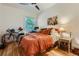 Bedroom featuring a large window, ceiling fan, hardwood floors, and cozy orange bedding at 2303-2305 W 32Nd Ave, Denver, CO 80211