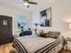Bright bedroom features wood floors, ceiling fan, exercise bike, and striking blue and gold abstract art piece at 2303-2305 W 32Nd Ave, Denver, CO 80211