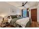 Bedroom featuring a large window, ceiling fan, hardwood floors, and cozy green bedding at 2303-2305 W 32Nd Ave, Denver, CO 80211