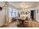 Bright dining room with hardwood floors, modern chandelier, and a collection of vintage cutting boards at 2303-2305 W 32Nd Ave, Denver, CO 80211