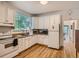 Bright kitchen with wood floors, white cabinets, appliances and a large window overlooking the backyard at 2303-2305 W 32Nd Ave, Denver, CO 80211