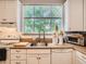 Cozy kitchen area with wood floors, bright window, and white cabinets at 2303-2305 W 32Nd Ave, Denver, CO 80211