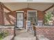 Cozy front porch featuring brick pillars and classic rocking chairs, perfect for relaxing outdoors at 2303-2305 W 32Nd Ave, Denver, CO 80211
