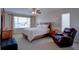 Spacious main bedroom featuring a king-size bed and a cozy armchair at 10272 Fawnbrook Ct, Highlands Ranch, CO 80130