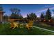 A well-manicured backyard featuring an expansive lawn and inviting yellow lounge chairs at 7065 E Caley Ave, Centennial, CO 80111
