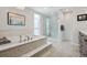 Luxurious bathroom with a soaking tub, glass-enclosed shower, and stylish tile accents at 7065 E Caley Ave, Centennial, CO 80111