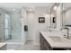 Bright bathroom featuring a glass-enclosed shower, double vanity, and modern lighting fixtures at 7065 E Caley Ave, Centennial, CO 80111