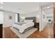 Bright bedroom featuring hardwood floors, a large bed, and an ensuite bathroom and walk-in closet at 7065 E Caley Ave, Centennial, CO 80111