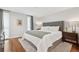 Bright bedroom featuring hardwood floors, a large bed, and windows dressed with simple, modern curtains at 7065 E Caley Ave, Centennial, CO 80111