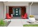 Inviting front porch featuring red Adirondack chairs, stylish planters, and a welcoming entrance to the home at 7065 E Caley Ave, Centennial, CO 80111