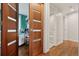 Hallway with wood-paneled doors showcasing access to a bedroom and a bathroom at 7065 E Caley Ave, Centennial, CO 80111