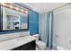 Bathroom showcasing a blue accent wall, shower with patterned curtain, and a vanity with a black drawers at 1301 Speer Blvd # 207, Denver, CO 80204