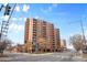An urban street scene with a tall building on the corner with many windows, balconies and crosswalks at 1301 Speer Blvd # 207, Denver, CO 80204