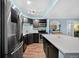The kitchen has modern stainless steel appliances, dark cabinetry, and a center island at 1301 Speer Blvd # 207, Denver, CO 80204